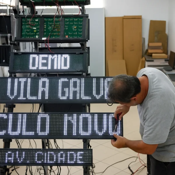 Técnico realizando manutenção em painel eletrônico Translux